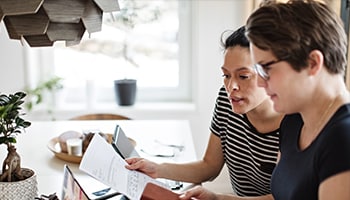 Two people working on paperwork together