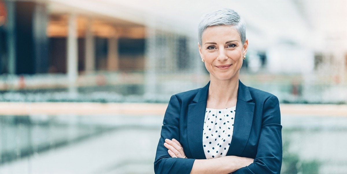 professional woman standing outside building with arms crossed