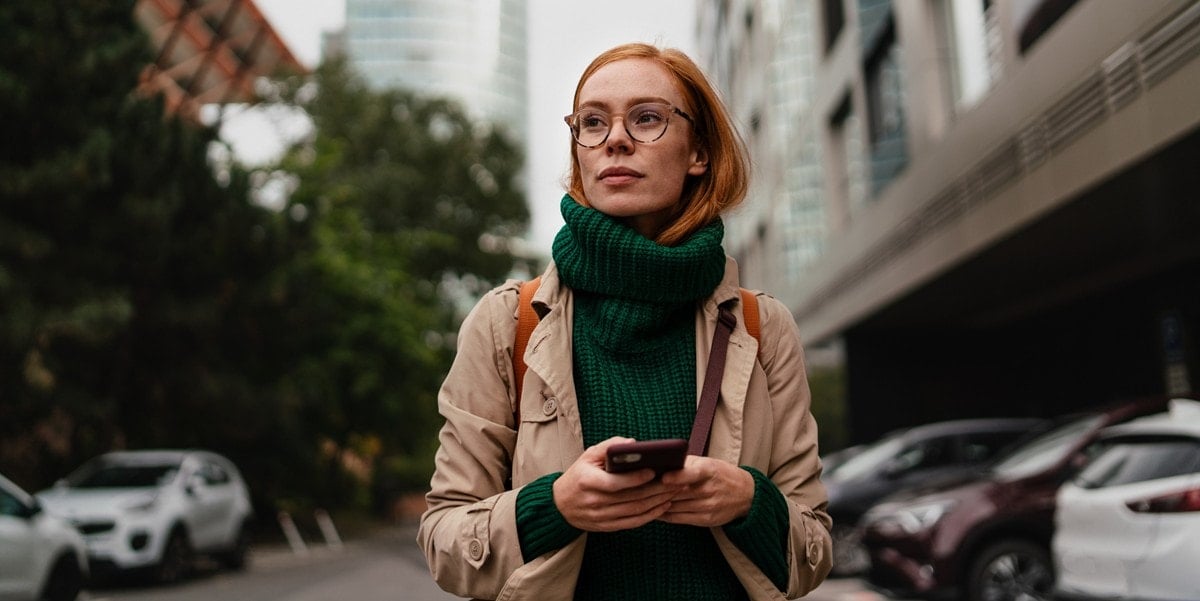 traveler in city, holding cellphone