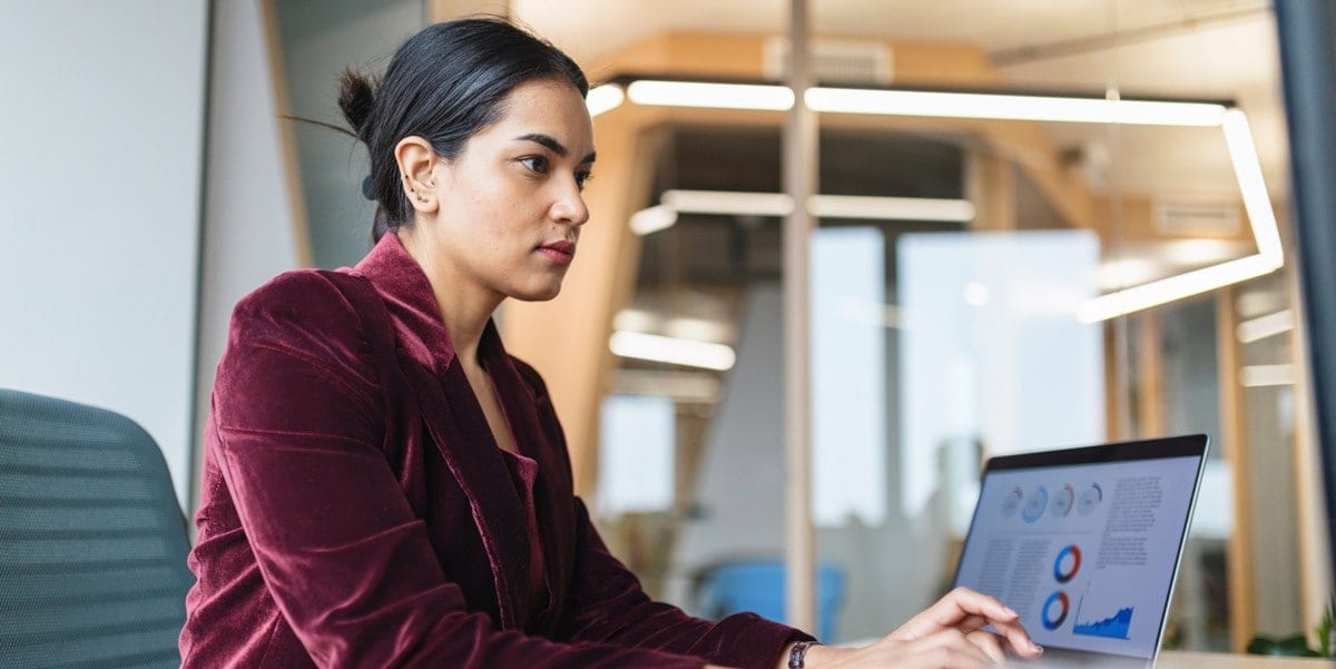 professional woman at desk working on a laptop